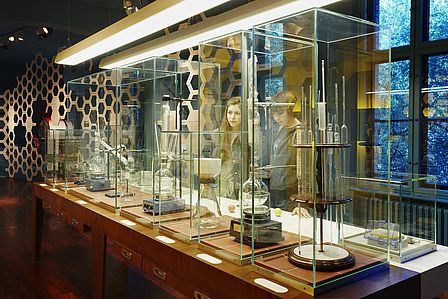 Blick in die Ausstellung "Pillen und Pipetten". In einer Vitrine stehen Instrumente, die zur Destillation, Filtration oder Extraktion chemischer Stoffe benutzt wurden.