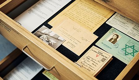 View into two opened drawers containing documents from Hella and Hannelore Zacharias. Identity cards can be seen, one of which has a Star of David. 