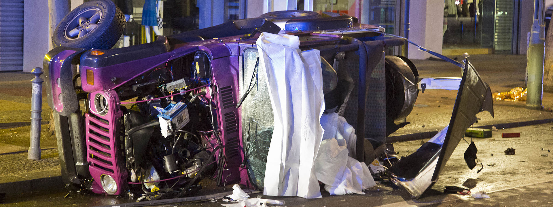 Der verunglückte rosa Jeep liegt auf der Seite auf der Straße.