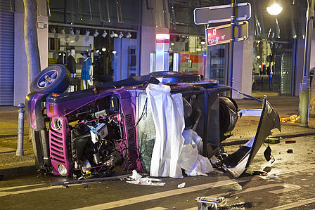Der verunglückte rosa Jeep liegt auf der Seite auf der Straße.