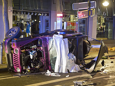 Der verunglückte rosa Jeep liegt auf der Seite auf der Straße.