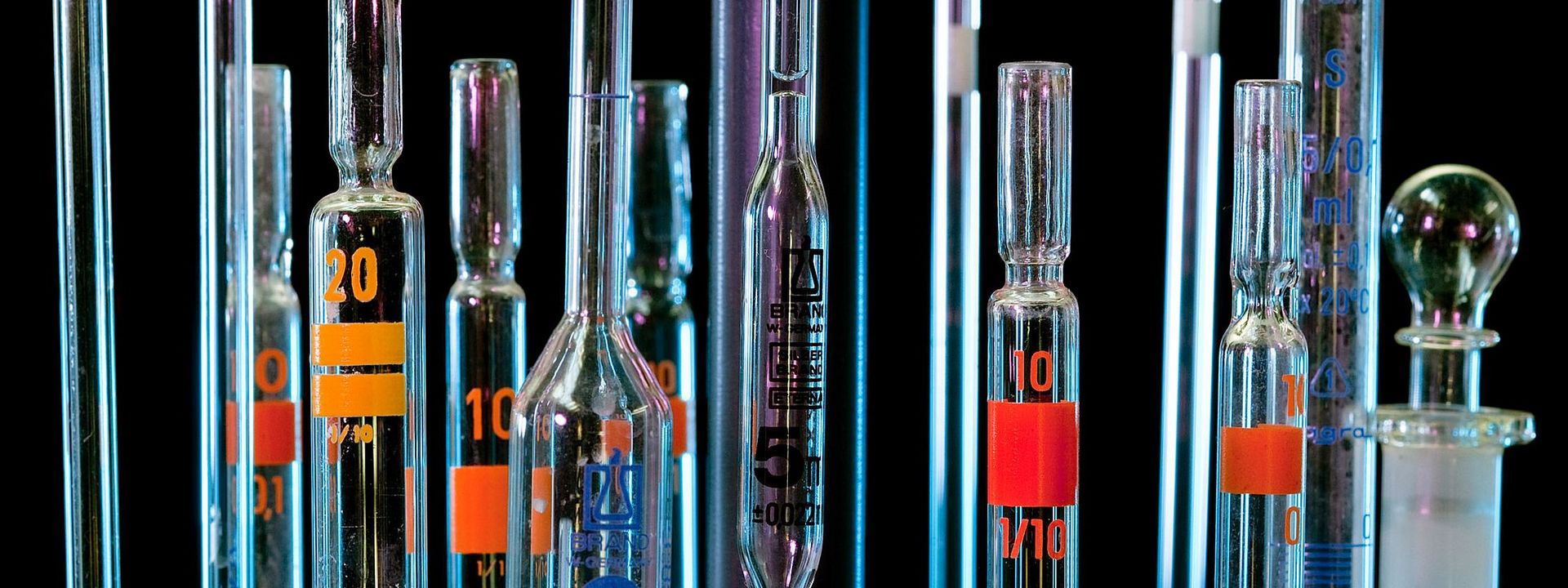 Ensemble von Glaspipettenspitzen vor einem schwarzen Hintergrund
