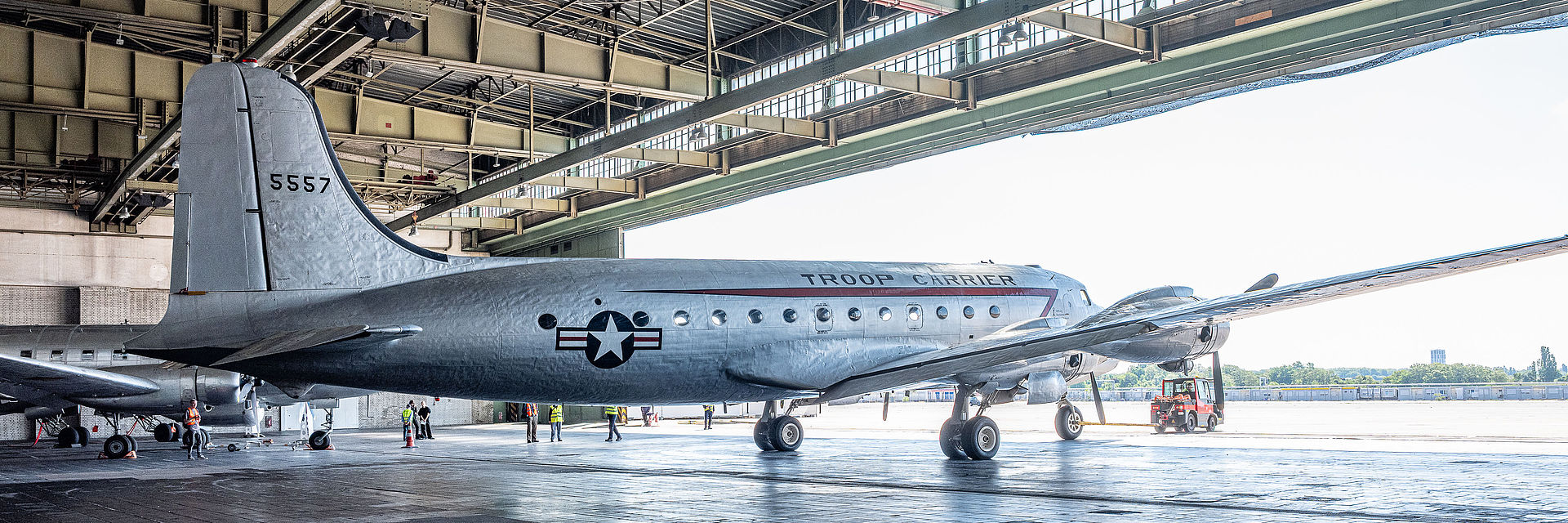 Blick auf ein silberfarbenes Flugzeug in einem Hangar.
