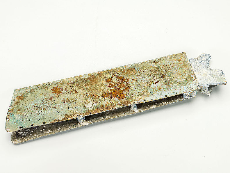 Das Wrackteil einer Flügelbombe aus dem Zweiten Weltkrieg ist aus Metall. Es ist rechteckig und zum Teil verrostet.