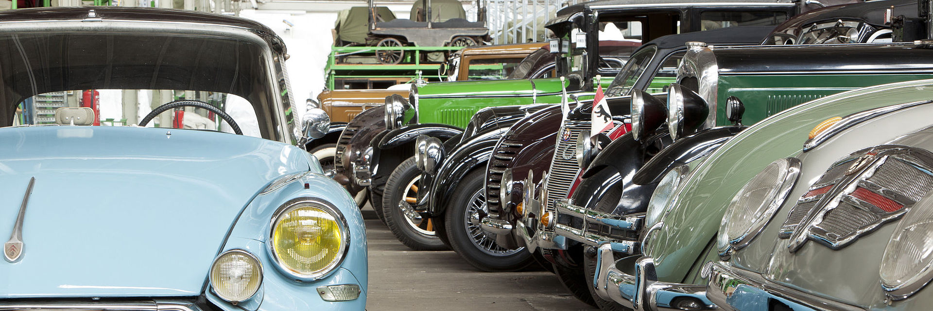 Blick in das Automobil-Depot des Deutschen Technikmuseums. Rechts stehen zahlreiche Autos dicht an dicht auf dem Boden und in einem großen Regal darüber. Links steht ein hellblauer Citroen DS 19.