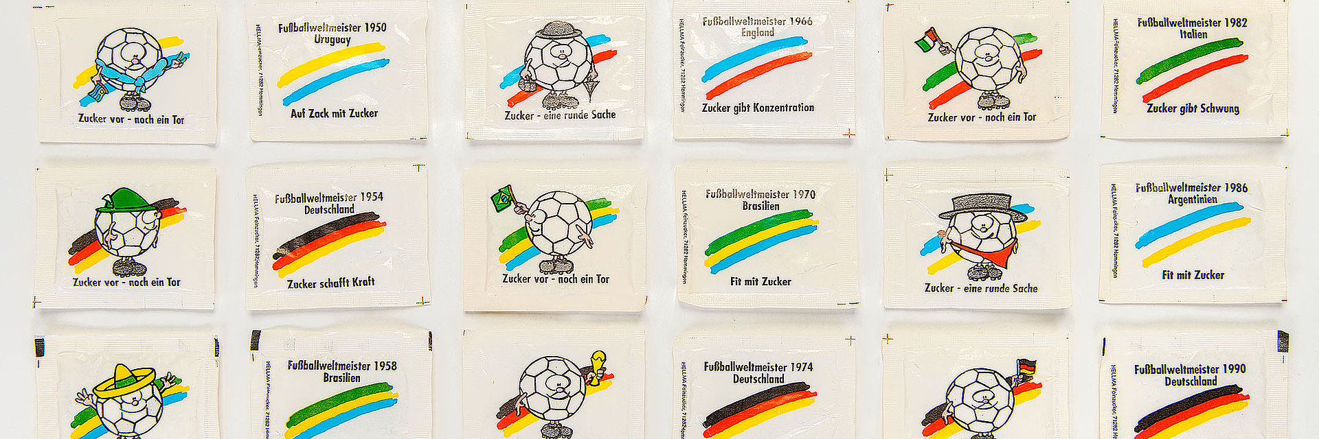 24 weiße rechteckige Zuckertütchen sind chronologisch in der Reihenfolge ihres Fußballweltmeister-Titels sortiert. Sie sind bedruckt mit Motiven wie Fußbällen, die landestypische Hüte tragen oder Fahnen schwenken sowie den jeweiligen Nationalfarben der jeweiligen Weltmeister und Werbesprüchen wie „Zucker – eine runde Sache“ oder „Zucker schafft Ausdauer“.