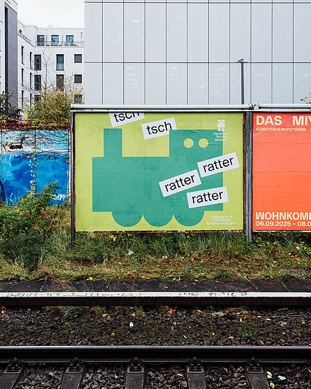 Plakat mit grüner Lokomotive und den Worten "ratter" und "tsch"