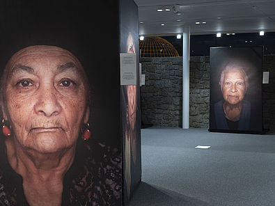 Blick in die Ausstellung "Ma Bistrass!". Zwei große Foto-Porträts von Überlebenden der nationasolzialistischen Verfolgung
