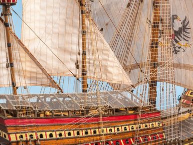 Nahaufnahme eines detailreichen Schiffsmodells mit gehissten Segeln. 