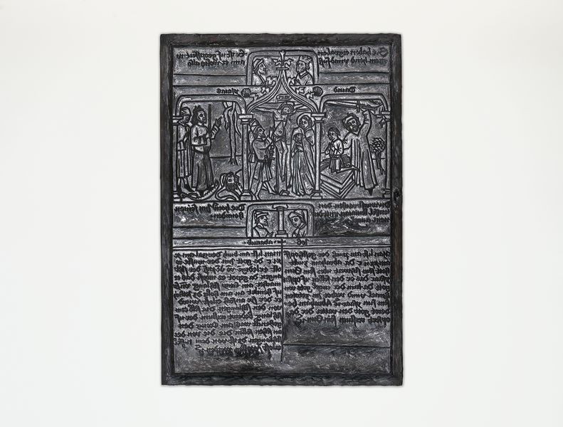 Der hölzerne Druckstock einer Armenbibel zeigt in der oberen Hälfte religiöse Motive. Im Zentrum ist Jesus am Kreuz, in der unteren Hälfte steht Text.