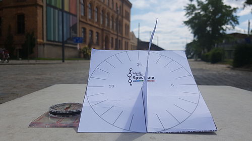 eine selbst gebastelte Sonnenuhr aus Papier zeigt die Uhrzeit an
