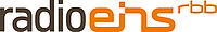 Das Logo von radio eins vom rbb: "radio" in schwarzen Buchstaben, "eins" und "rbb" in orangenen Buchstaben.