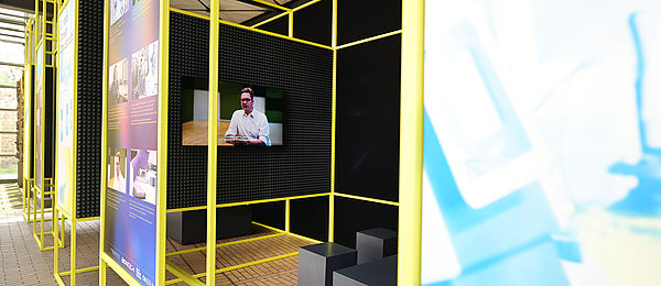 Blick in die mit schwarzem, schallisolierendem Material verkleidete Kabine, in der Filmsequenzen zur Ausstellung gezeigt werden.