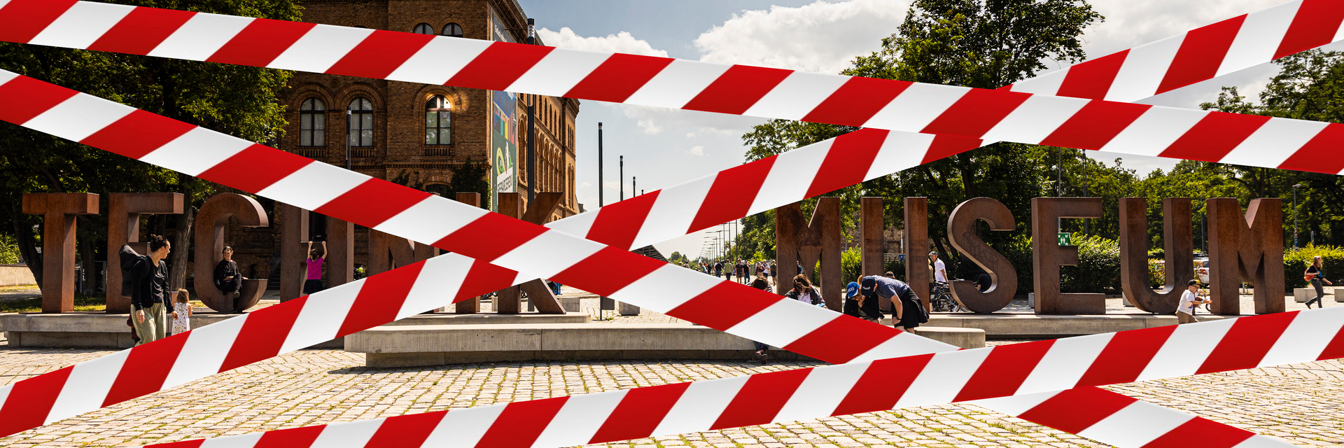 Blick auf den Vorplatz des Deutschen Technikmuseums mit der Wortskulptur "Technik Museum", davor als ist als Grafik ein rot-weißes Flatterband gesetzt.