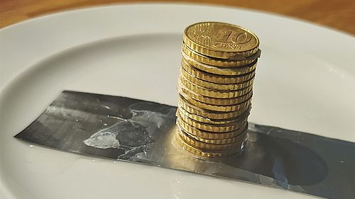 Auf einem Teller liegt eine Metallplatte auf der einige 10-Cent-Münzen gestaplet sind. 