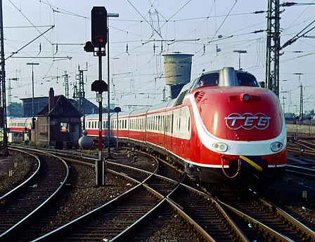 Ein rot-weißer Zug mit rundem Kopf fährt auf einer Schiene ins Bild. Es handelt sich um den 1957 gebauten TEE.