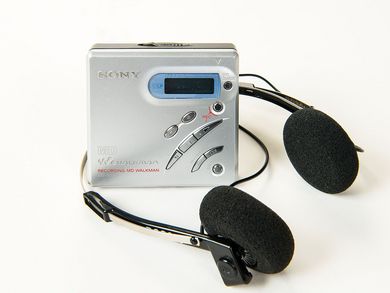 Dieser MiniDisc-Rekorder MZ-R500 hat die Form eines kleinen quadratischen Kästchens mit schräg angeordneten Funktionstasten und silbern gefärbter Oberfläche aus Aluminium.