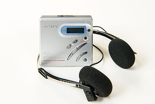 Dieser MiniDisc-Rekorder MZ-R500 hat die Form eines kleinen quadratischen Kästchens mit schräg angeordneten Funktionstasten und silbern gefärbter Oberfläche aus Aluminium.