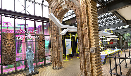 Blick in den Lokschuppen mit dem Fürstenportal, durch das ein Teil des Ausstellungsmoduls herausragt.