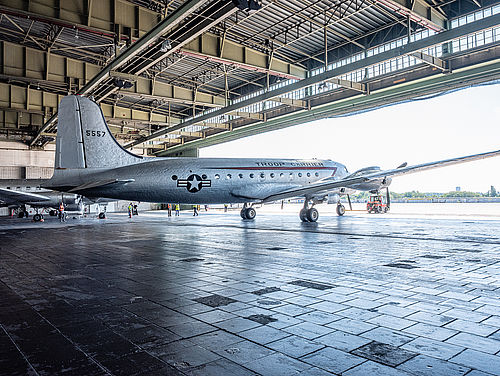 Blick auf ein silberfarbenes Flugzeug in einem Hangar.