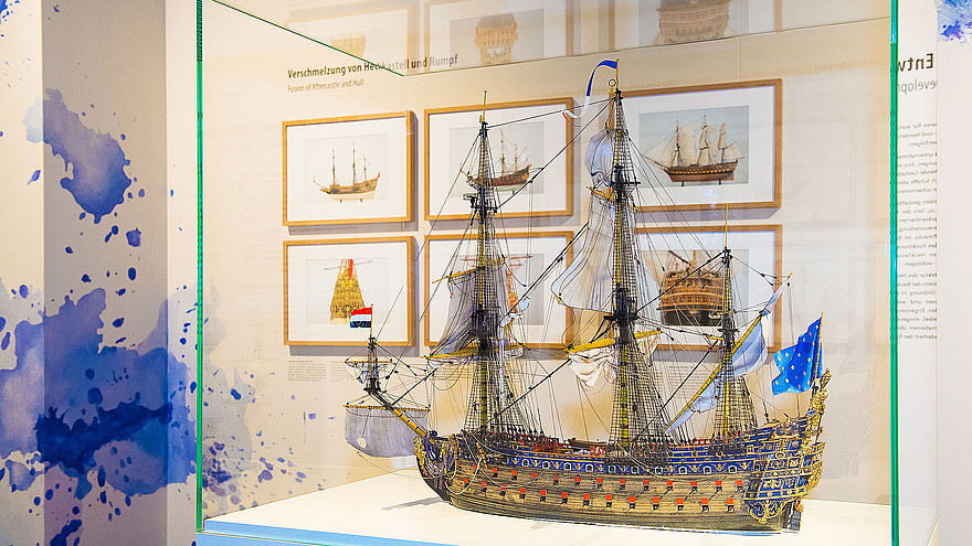 Im Vordergrund eine Vitrine mit einem Model des Barockschiffes LE SOLEIL ROYAL, im Hintergund gerahmte Schiffszeichnungen.