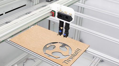 Großaufnahme eines metallfarbenen Lasercutters. Der sogenannte LaserDuo ist ein großer Lasercutter für präzise Schnitte in Holz und Acryl. 