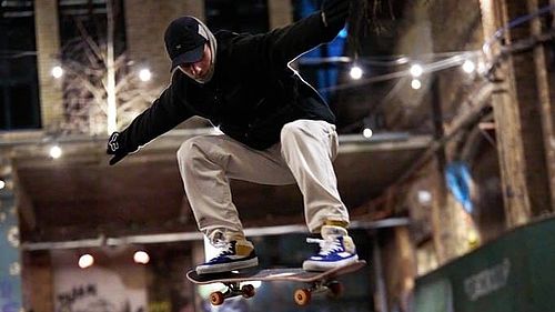 Ein Skateboarder bei einem Sprung in einer Skateboardhalle