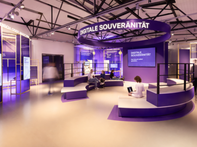 Blick in den Erlebnisraum Digitale Souveränität mit lila Podesten und Ausstellungseinheiten