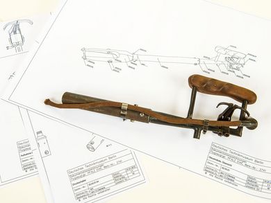 Auf der ausgebreiteten technischen Zeichnung ist die Steuersäule eines Jagdflugzeugs D VIII der Pfalz Flugzeugwerke zu sehen. Als Vorlage diente die danebenliegende Flugzeug-Steuersäule. Sie wurde zum Zweck der Restaurierung und Vermessung aus der D VIII des Museums ausgebaut. 