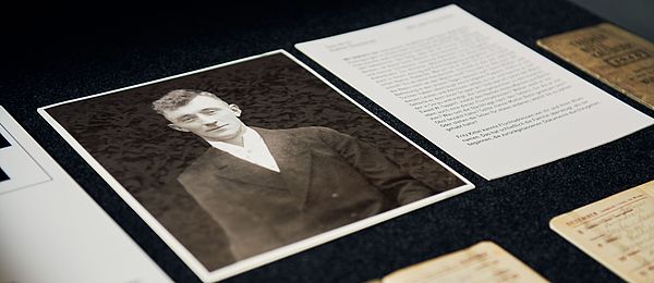 An open drawer containing a black and white photograph of a young man in a white shirt and dark jacket. Right next to it is a typewritten piece of paper. The name "Fritz Kittel" is clearly visible.