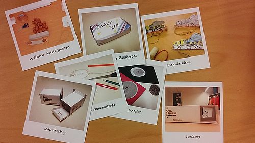Auf einem Tisch liegen Fotos von Ergebnissen der verschiedenen Workshops 